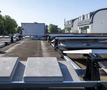 An array of solar panels installed on a flat rooftop on a sunny day