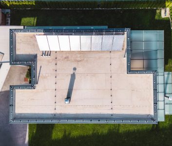 Aerial view of a modern house with solar panels on the roof top. Modern architecture, suburban home, country side living, luxury lifestyle. Renewable energy, solar panels.